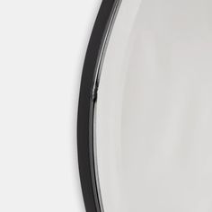 an oval mirror with black frame and white background