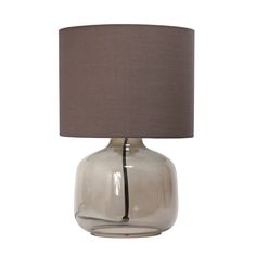 a glass table lamp with a grey shade on it's base and a dark brown linen lampshade