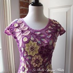 a mannequin wearing a purple crochet dress with flowers on it's chest