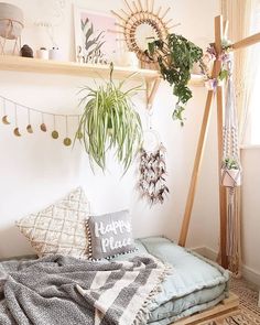 a bed with pillows, blankets and plants on it