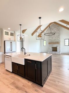 a large kitchen with an island in the middle and wood flooring on the other side