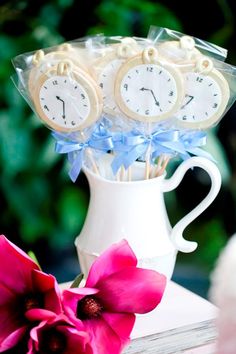 three clocks are sitting in a vase with flowers