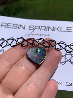 Each resin pendant is handmade to order, therefore no two chokers are identical! However, I try to get as close to the listing photos as possible :) One size fits all black elastic choker necklace. Heart width is approximately 19mm and is made with epoxy resin, black liquid color pigment, and white chunky holographic glitter ✨ Thanks for visiting my shop! 🖤 Trendy Heart Pendant Choker For Gift, Trendy Heart Pendant Choker As Gift, Trendy Heart Charm Choker As Gift, Grunge Heart-shaped Necklace For Gifts, Adjustable Rave Choker For Gift, Adjustable Rave Choker As Gift, Adjustable Rave Choker For Gifts, Adjustable Iridescent Choker Jewelry, Black Rave Style Choker Jewelry