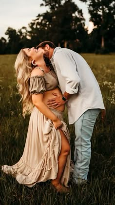 a man and woman kissing in the grass