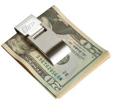 a money clip sitting on top of one hundred dollar bills