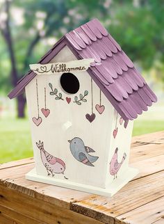 a birdhouse with birds and hearts painted on it