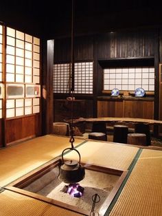 a tea pot sitting on top of a stove in a room filled with wooden walls