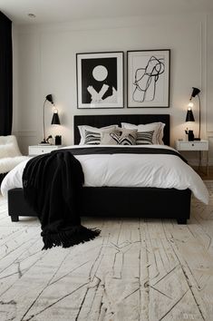 a white and black bedroom with pictures on the wall above the bed, two nightstands