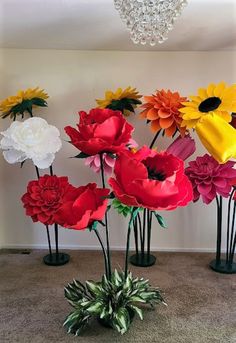 there are many flowers in the vases on the floor and one is red, yellow, white, and green