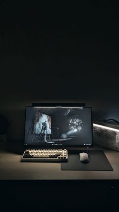 a desktop computer sitting on top of a desk next to a mouse and keyboard in the dark