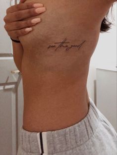 the back of a woman's stomach with her hand on her hip and writing on it