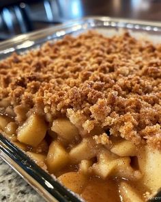 a casserole dish with apples and crumbs on top