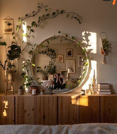 a person taking a photo in front of a mirror with plants on the wall behind it