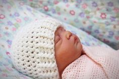 a newborn baby is sleeping in a crocheted hat