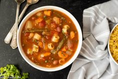 two bowls of soup on a table with silver spoons