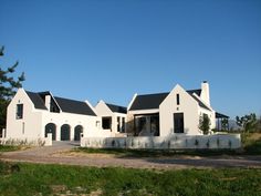 a large white house sitting on top of a lush green field