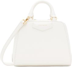 Structured and tumbled buffalo leather top handle bag in white. · Twin rolled carry handles · Adjustable and detachable crossbody strap · Logo stamp at face and back face · Two-way zip closure · Card slot at interior · Canvas lining · Logo-engraved gold-tone hardware · H5.5 x W6.5 x D3.5 Supplier color: Ivory White Travel Bag With Round Handle, White Satchel With Detachable Strap And Round Handle, White Shoulder Bag With Round Handle For Travel, White Bag With Gold-tone Hardware And Round Handle, White Bags With Gold-tone Hardware And Round Handle, White Shoulder Bag With Round Adjustable Handle, White Shoulder Bag With Adjustable Round Handle, White Shoulder Bag With Round Handle, Everyday White Satchel With Round Handle