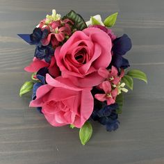 a bouquet of pink and blue flowers sitting on top of a wooden table