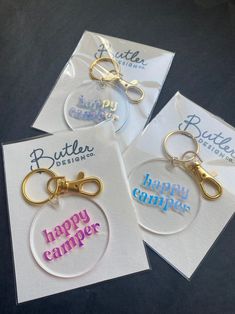 three happy campers keychains with the words happy camper printed on them