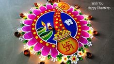 a colorful diya with the words happy dhantes written on it and lit candles