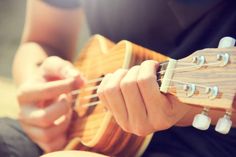 a person playing an ukulele with their fingers