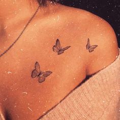 the back of a woman's shoulder with three butterflies on it