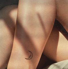 a woman with a small tattoo on her left arm and the moon behind her back