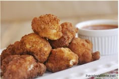 some fried food on a white plate with dipping sauce