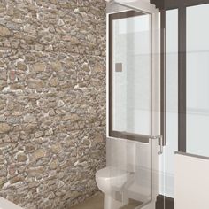 a bathroom with a stone wall and glass shower door next to a toilet in the corner