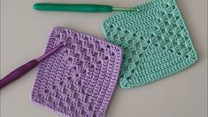 two crocheted squares and a knitting needle on a table