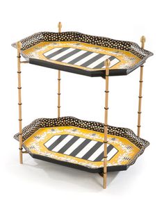 two tiered trays with black and white stripes on them, each holding an ornate design