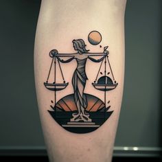 a lady justice tattoo on the right leg with scales and an orange sun in the background