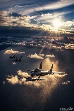 three airplanes flying in the sky above some clouds and sunbeams with rays coming through them