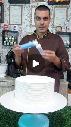 a man standing in front of a white cake