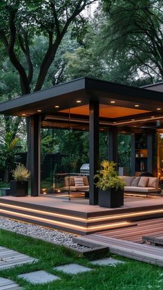 an outdoor living area in the middle of a park at night with lights on it