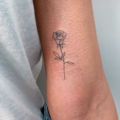 a single rose tattoo on the arm