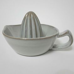 a white bowl with a silver handle on it