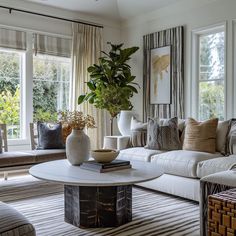 a living room filled with lots of furniture next to two large vases on top of a coffee table