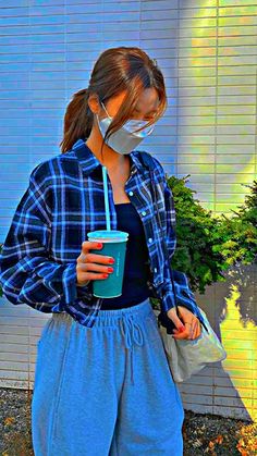 a woman wearing a face mask and holding a cup