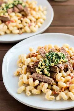 two white plates filled with pasta and meat