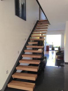 there is a wooden stair case on the wall next to the stairs in this house