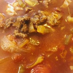 a close up view of a bowl of soup with meat and vegetables in broth