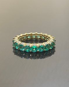 an emerald colored ring sitting on top of a table