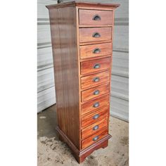 a tall wooden cabinet with many drawers