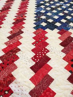 a red, white and blue quilt is on display