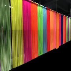 a wall that has many different colored lines hanging from it's sides and on top of each other