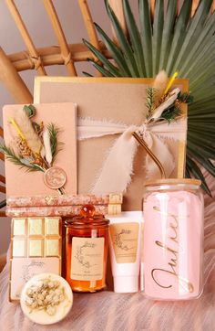 an assortment of items displayed on a table next to a potted plant and candle