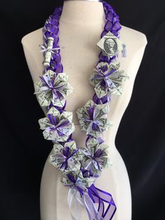 a white mannequin with purple ribbon and dollar bills on it's neck