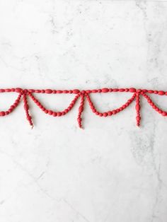 red beaded garland on white marble background