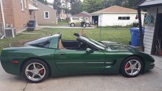 a green sports car parked in front of a house